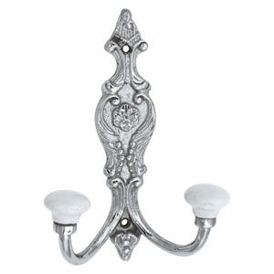 May include: A silver-toned metal wall hook featuring an ornate, embossed floral and scrollwork design on the vertical backplate. The hook has two curved arms, each tipped with a smooth, round, white ceramic knob for hanging items securely.