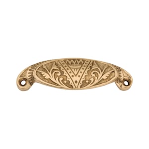 Pode incluir: Um puxador de armário dourado, em forma oval, com intrincados padrões florais e geométricos. O puxador tem dois orifícios para montagem e é projetado para móveis. Esta ferragem decorativa adiciona um toque de elegância a qualquer armário ou gaveta. (Medidas em cm)