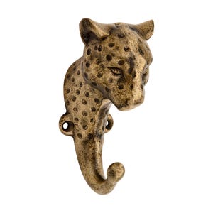 May include: A wall-mounted hook crafted from antique brass-toned metal, featuring the sculpted head and neck of a leopard. The surface displays a textured, spotted pattern across the feline form, with two circular mounting holes at the base.