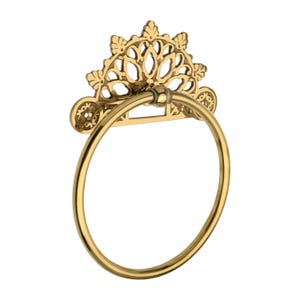 May include: A gold-colored towel ring with an ornate, decorative top. The top features a detailed, openwork design with floral and leaf motifs. The circular ring is smooth and polished, suitable for a bathroom.