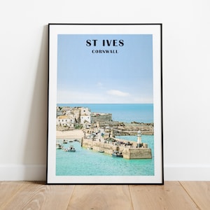 May include: A colorful illustration of St. Ives, Cornwall, featuring a harbor with boats and a lighthouse. The text "ST IVES" and "CORNWALL" is printed in black at the top of the image.