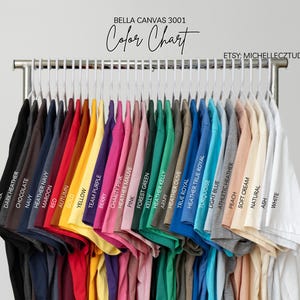 A clothing rack displaying a variety of colorful t-shirts, each with a different color and design.