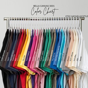 A clothing rack displaying a variety of colorful t-shirts, each with a different color and design.