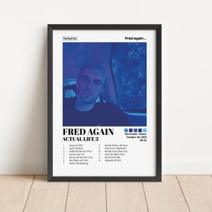 May include: A framed poster featuring a blue-toned image of a person, with the text "FRED AGAIN ACTUAL LIFE 3" in bold white letters. The poster includes a tracklist and the text "Electronic Dance October 28, 2021".