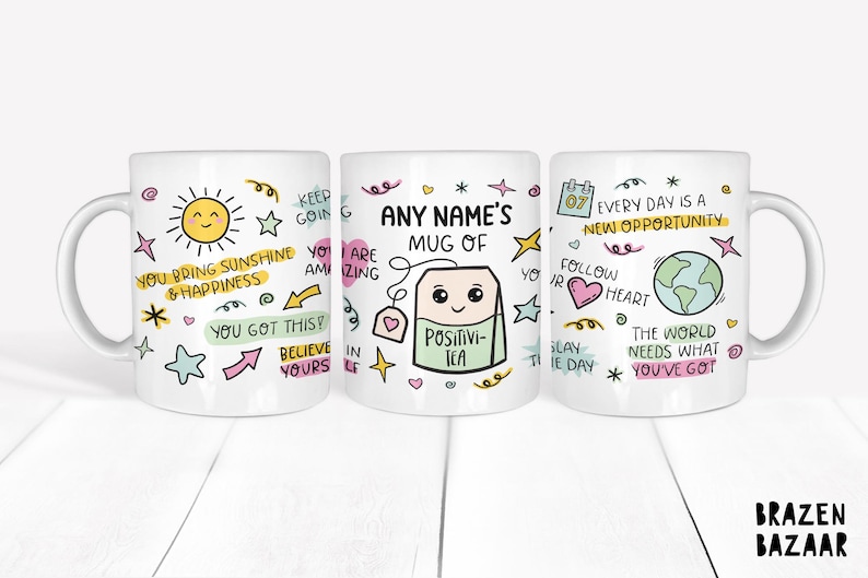 May include: Three white ceramic mugs with colorful hand-drawn designs and inspirational quotes. The mugs feature a sun, a tea bag with a face, and a globe. The text on the mugs includes "You bring sunshine & happiness", "Any Name's Mug of Positivi-Tea", and "Every day is a new opportunity".