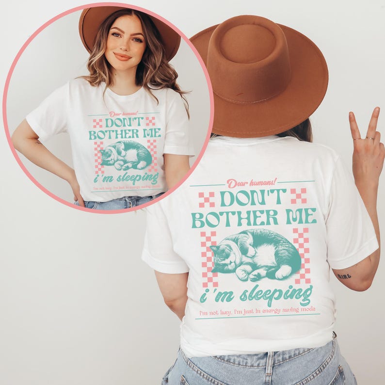 May include: White t-shirt with a graphic of a cat sleeping and the text "Dear humans! Don't bother me, I'm sleeping. I'm not lazy, I'm just in energy saving mode."