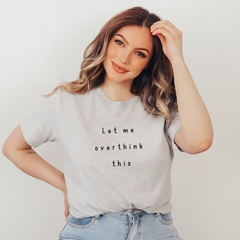 Puede incluir: Una camiseta gris con el texto "Let me overthink this" impreso en negro.
