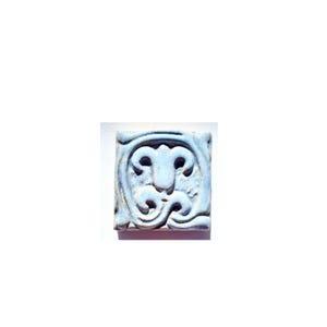 May include: A light blue ceramic tile with a raised design of a stylized flower with three petals. The tile has a slightly textured surface.