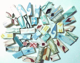 May include: A collection of colorful, patterned ceramic tiles in various shapes and sizes. The tiles feature geometric designs, swirls, and abstract patterns in shades of blue, green, yellow, red, and white.