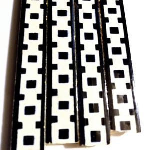 以下が含まれることがあります： 黒と白の正方形の幾何学模様が施されたセラミックタイルのストリップが4本