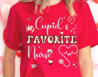 May include: Red t-shirt with the text "Cupid's Favorite Nurse" in white and gold lettering. The shirt features a heart with a heartbeat line, a stethoscope, an arrow, and a nurse's cap.
