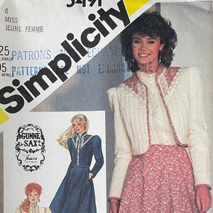 以下が含まれることがあります： Gunne Saxのデザインが特徴のSimplicityの縫製パターン5491。 パターンパッケージには、花柄のスカート、白いジャケット、長袖のブラウスを着た女性が描かれています。 パッケージは黄色と白で、Simplicityのロゴが入っています。