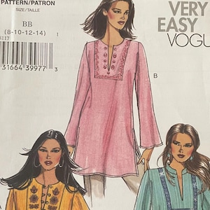 Puede incluir: Un sobre de patrón de costura Very Easy Vogue V8117 para tallas 8-10-12-14. El frente muestra ilustraciones de tres túnicas de manga larga con escotes divididos y paneles bordados decorativos, presentadas en colores rosa, amarillo y azul claro.