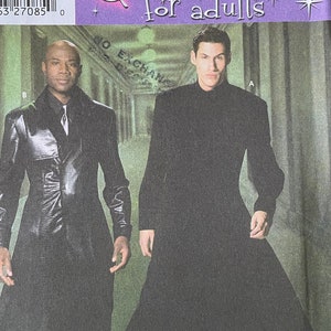 Puede incluir: Patrón Simplicity 5386 para disfraces para adultos. El patrón incluye dos figuras que llevan abrigos largos negros. El texto del patrón dice "Disfraces para adultos".