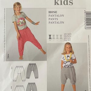 May include: A Burda Kids sewing pattern for children's trousers. The pattern includes illustrations of the trousers and sizing information in both EUR and US sizes. The cover features the text "HOSE, PANTALON, PANTS, PANTALÓN".
