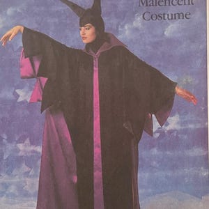 Puede incluir: Un patrón de costura Simplicity vintage para un disfraz de Maléfica. El patrón presenta a una mujer con una túnica negra con detalles morados y un tocado con cuernos. El patrón está etiquetado "8329" e incluye el logotipo de Walt Disney.