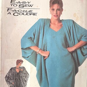 Puede incluir: Patrón de costura Simplicity con un vestido y una chaqueta color turquesa. El patrón incluye el texto "E-A-S-Y TO SEW" y "F-A-C-I-L-E A COUDRE". El paquete muestra a una mujer con el vestido y la chaqueta.