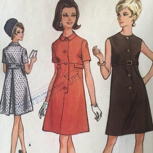May include: A vintage sewing pattern for a dress in two styles. The pattern is for misses sizes 12-14, bust 34-36. The pattern is from McCall's and is number 9185. The dress is shown in two versions, one with short sleeves and a collar, and one sleeveless with a belt.