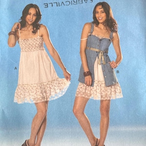 May include: A Burda Young Fashion sewing pattern featuring two dress designs. The pattern includes sizes 6-18. The image shows two women modeling the dresses. The text on the pattern reads "All patterns with seam and hem allowances."