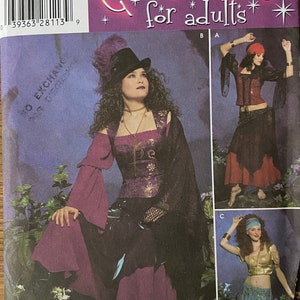 May include: Simplicity pattern number 4484 for costumes for adults. The pattern includes three different costume designs. The first design is a purple and black costume with a hat. The second design is a red and black costume with a red headband. The third design is a teal and gold costume with a blue headband.