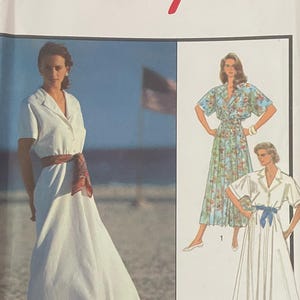 May include: A vintage sewing pattern labelled "Style" with the number 1540. The pattern shows illustrations of women's dresses, including a white dress with a brown belt and a floral print dress. The pattern includes the text "FABRICVILLE".