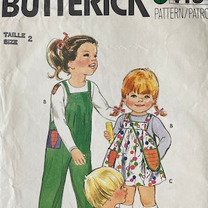 May include: Vintage Butterick pattern 4184 featuring illustrations of children's overalls and dresses. The pattern cover shows three children in colorful outfits, including green overalls, orange shorts, and a floral dress. The size is 2.