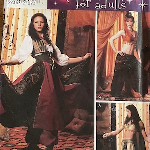 Puede incluir: Un patrón de costura para disfraces de adultos. El patrón es para un disfraz de danza del vientre con falda, top y pantalones. El patrón es de Simplicity y es para las tallas 6, 8, 10 y 12. El patrón está adornado con  "onso" y "Wrights".