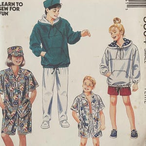 May include: McCall's sewing pattern featuring illustrations of children's clothing, including a hoodie, shorts, and a button-up shirt. The pattern includes the text "Learn to Sew for Fun" and the number 5304.
