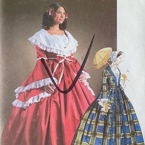 May include: Vintage McCall's Costumes sewing pattern for two dresses. The pattern is for sizes 6-8-10-12. The first dress is a red gown with white lace trim and a ruffled skirt. The second dress is a plaid dress with a blue, green, and yellow plaid pattern. The pattern is labeled "M4415".