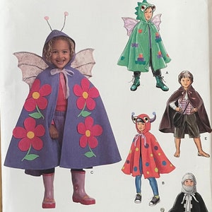 May include: A sewing pattern for children's capes. The pattern includes four different designs: a butterfly cape with pink flowers, a dragon cape, a ladybug cape with red and yellow polka dots, and a knight cape with a sword. The pattern is for sizes 3-8.
