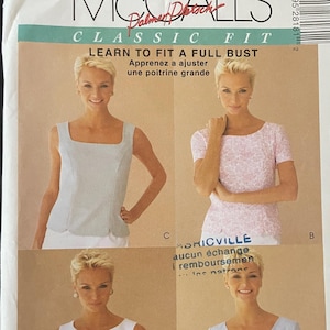 以下が含まれることがあります： 4種類のブラウスのデザインが描かれた、McCall'sのソーイングパターン封筒。「CLASSIC FIT」と「LEARN TO FIT A FULL BUST」の文字が記載されています。サイズはB（8-10-12）です。