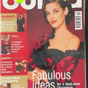 Op de afbeelding: Omslag van het vintage tijdschrift Burda World of Fashion. De omslag toont een vrouw in een rood-zwarte geruite top. Tekst bevat "Fabulous ideas for a best-ever Christmas" en "12/2001". Andere tekst promoot mode en feestdagen.
