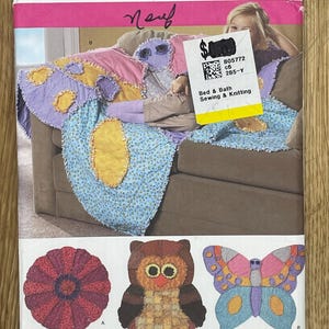 May include: Simplicity sewing pattern 2935 for a bed and bath project. The pattern features a colorful, patchwork design with an owl, butterfly, and flower. The pattern is one size.