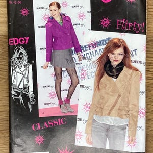 May include: A Simplicity sewing pattern featuring a suede jacket and other clothing designs. The pattern cover has the text "SUEDE says" and "Flirty!" in pink, with images of models wearing the clothing. The size range is listed.