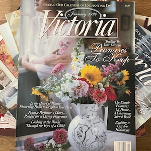 May include: A magazine cover featuring a bouquet of flowers in a white pitcher with the title "Victoria" and the text "Promises to Keep" in a red and black font. The magazine cover also features the text "Tending to Your Dreams" and "January 1994".