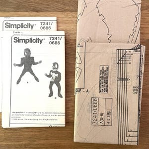 May include: Simplicity sewing patterns featuring Spider-Man and Venom costumes. The patterns are labeled 7241/0686 and include illustrations of the characters. The packaging is tan and white, with text in English and French.