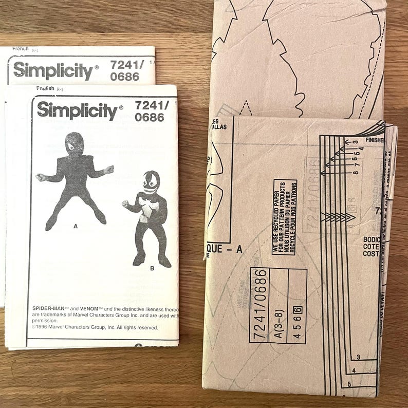 May include: Simplicity sewing patterns featuring Spider-Man and Venom costumes. The patterns are labeled 7241/0686 and include illustrations of the characters. The packaging is tan and white, with text in English and French.