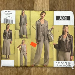 May include: Vogue pattern V1055 featuring a women's suit designed by Adri. The pattern includes a jacket, skirt, and pants. The package shows multiple images of the finished garments in a neutral color. The size range is 6-8-10-12.