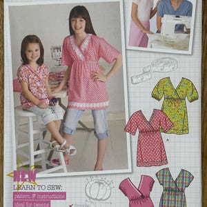 May include: Simplicity sewing pattern 2437 for girls' tops. The pattern includes instructions and is designed for sizes HH 3, 4, 5, and 6. The cover features a photo of a girl wearing a pink polka-dot top and the text "Learn to Sew".