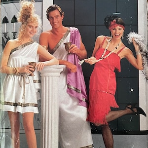 May include: A vintage sewing pattern for three costumes: a white toga with gold trim, a red flapper dress with fringe, and a purple toga with gold trim. The pattern is from Butterick and the number is 4199. The pattern is for all sizes.
