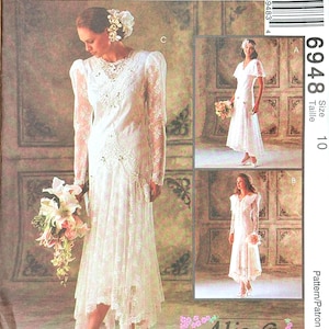 May include: A McCall's sewing pattern for a wedding dress. The pattern features a white lace dress with long sleeves and a high-low hemline. The image includes three different dress styles, with the number 6948 and size 10 visible.