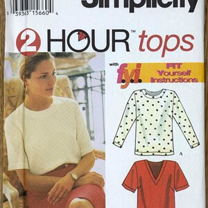 May include: Simplicity sewing pattern 9096 for tops. The pattern includes illustrations of three different top designs. The front of the pattern features a woman wearing a cream-colored top and a red skirt. The text "2 HOUR tops" is visible.