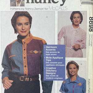 May include: A sewing pattern envelope with the text "sewing with nancy" and "Patterns by Nancy Zieman for MCCALL'S." The envelope shows images of women's clothing designs, including a denim shirt and a colour-blocked shirt with decorative stitching.