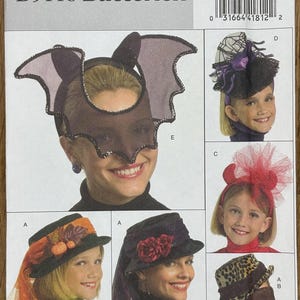 Puede incluir: Un patrón de costura Butterick, B5118, con varios diseños de tocados de disfraces. Los diseños incluyen una máscara con temática de murciélago, un sombrero de telaraña, una diadema de tul roja, un sombrero con follaje de otoño, un sombrero con rosas rojas y un sombrero con estampado de leopardo.