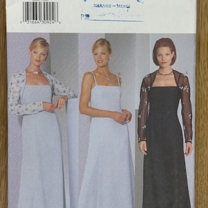 May include: A sewing pattern for a long dress with a sleeveless bodice and a skirt that falls to the floor. The pattern includes two different styles: one with a white dress and a floral print shawl, and one with a black dress and a sheer shawl with floral embellishments. The pattern is for sizes 6-8-10.