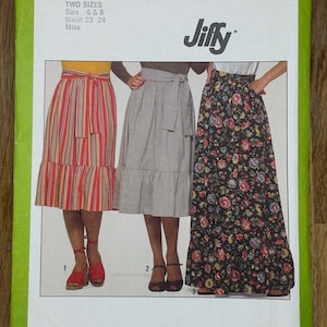 Peut inclure: Patron de couture Simplicity 8304. Le patron présente trois modèles de jupes. Le devant du patron est vert avec le texte "Simplicity 8304" et "Jiffy". Le patron contient deux tailles, 6 & 8, et des tailles de taille de 58,4 cm et 61 cm.