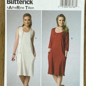 Può includere: Un modello di cucito intitolato "B6213 Butterick Katherine Tilton" con due modelli di abiti. Uno è un abito bianco senza maniche con cerniera e tasche. L'altro è un abito rosso con bottoni e tasche. La taglia del modello è B5.