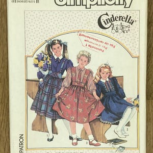 May include: Simplicity Cinderella sewing pattern, size 8. The pattern features illustrations of three young girls in dresses. The pattern's text includes "PATTERN/PATRON", "SIZE 8", and "Cinderella".