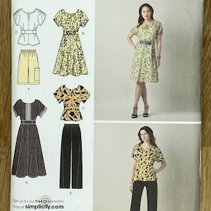 Può includere: Una busta per cartamodello Simplicity 2615 per le taglie AA 10, 12, 14, 16, 18. La confezione mostra illustrazioni e fotografie di vari capi, tra cui abiti, top e pantaloni con motivi floreali e astratti in giallo, nero e bianco.
