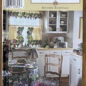 Op de afbeelding: Simplicity Home Kitchen Essentials patroon. De afbeelding toont een keukenscène met bijpassende gordijnen, tafelkleed en stoelkussens met een druivenontwerp. Het patroon bevat schorten, ovenwanten en andere keukenaccessoires.